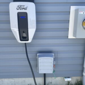 Ford EV charger mounted on a wall, showcasing installation alongside a power meter, relevant for Recessed Lighting Installation.