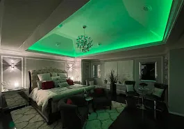 Modern bedroom with green LED cove lighting